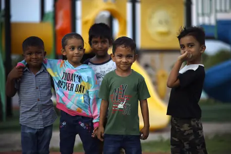 Five young boys take a break from running around their neighborhood playground on Gan island, Laamu Atoll, the Maldives.