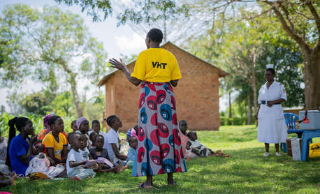 A UNICEF-supported community mobilizer prepares community members for a vaccination drive in Uganda.