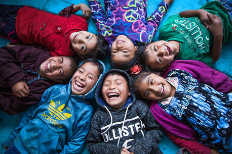 Seven schoolchildren, members of the indigenous community of Chicoy of Todos Santos Cuchumatánin, who live in the province of Huehuetenango, Guatemala, laugh and smile together on the floor of their classroom on the last day of school.