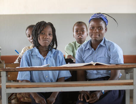 In Mozambique, Josefa, 14, left, and Margarida, 15, sit together in class at Primeiro de Junio Primary School in Buzi district, Sofala province, a climate-proof school constructed as part of UNICEF’s climate-resilient infrastructure program in the country.