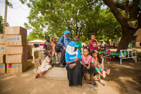UNICEF staff engage with displaced children at a gathering point in Madani.