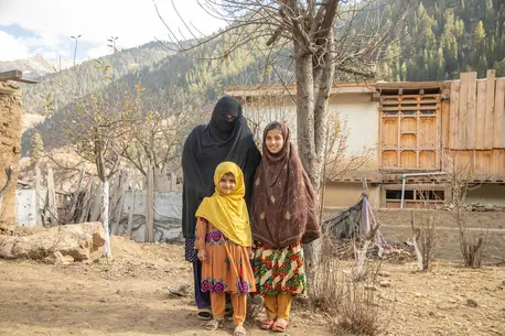 Saeed Khanum stands with two of her six daughters in rural Afghanistan.