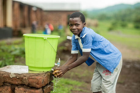 Usman Ali, a 13-year-old standard six student from Mukuyu Primary School in Dedza, Malawi, diligently practices good hygiene by washing his mango before eating it.