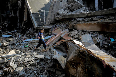 Mohammed, 9, walks over the rubble of his destroyed home on Omar Al-Mukhtar Street in Gaza City on Jan. 11, 2024.