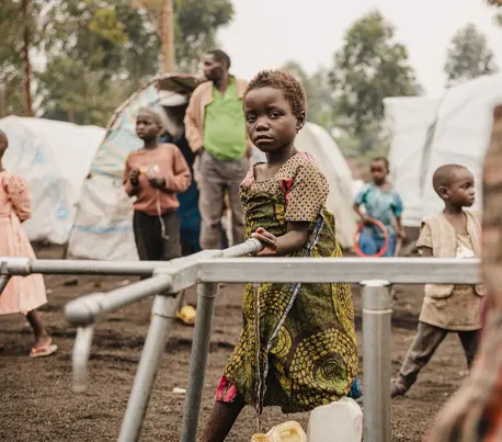 A little girl draws water at the Kizimba site for displaced people in Sake, North Kivu province, DRC. The standpipe was installed with UNICEF support.