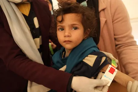 In the Gaza Strip on Feb. 15, 2024, a UNICEF-trained screener measures 2-year-old Leen's mid-upper arm circumference to diagnose severe acute malnutrition.