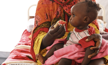 A mother feeds her baby Ready-to-Use Therapeutic Food at a refugee site in Adre, eastern Chad, near the Sudan border.