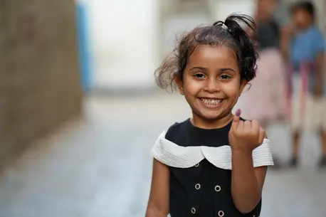In Aden, Yemen, a young girl beams with pride and joy, displaying her marked finger after being vaccinated against polio as part of an ongoing UNICEF-supported precautionary campaign.