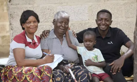 A UNICEF-supported volunteer (far left) visits a family affected by cholera in Zambia.
