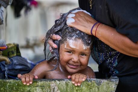 Maife, 5, washes up with safe water at UNICEF-supported Lajas Blancas migrant reception station in Panama..