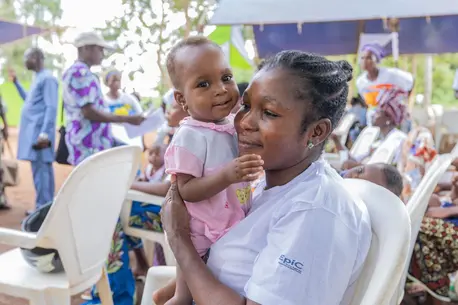 On World Malaria Day 2024, a mother holds her child at the health center in Allada, southern Benin, where children have started getting vaccinated against malaria with UNICEF support.