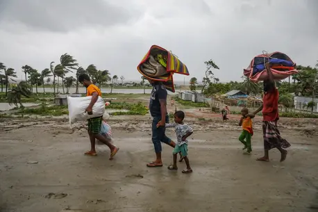 Parents and children head to a shelter ahead of Cyclone Remal's landfall in Bangladesh on May 26.