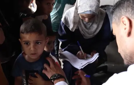 A health worker from a UNICEF-supported pediatric clinic screens children for malnutrition and delivers high-energy biscuits in northern Gaza Strip on May 27, 2024.