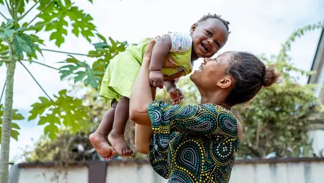 Ngozi Chike plays with her 6-month-old son Chidiebube at Otuocha Primary Healthcare Center, Anambra State, Nigeria, where the child received receiving a dose of Vitamin A through a UNICEF-supported program.