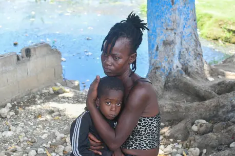 A mother holds her child close in Haiti, where escalating violence is pushing more and more families from their homes.