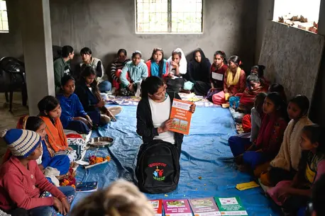 A peer facilitator displays materials from the Rupantaran tool kit provided by UNICEF to a class of adolescent girls in Nepal’s Maharajganj Municipality.