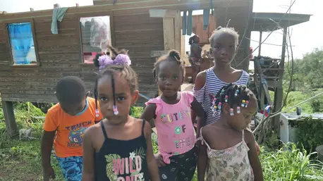 Young children gather outside their hurricane damaged home in La Fortune, St. Patrick, Grenada, on July 2, 2024.