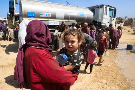 Aseel, one-year-old, holding a bottle of water filled from a UNICEF-supported water tank in Deir al-Balah, in the Gaza Strip, thanks to the government of Australia and Sweden.