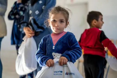 A girl holds a UNICEF winter clothing kit in southern Lebanon.