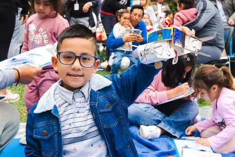A boy proudly shares his art project during a UNICEF-supported event in Peru.
