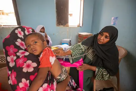 A mother brings her child for treatment at a UNICEF-supported mobile clinic in Adama locality, Atbara, River Nile state, Sudan.