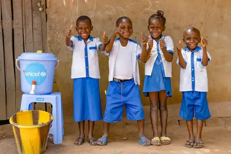 Students at Ecole Primaire Ilako in Mbandaka, Democratic Republic of the Congo, stand outside their classroom after washing their hands. UNICEF installed handwashing stations at the school to help students protect themselves from Ebola.