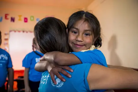Damari, 7, hugs Pilar Escudero. UNICEF communication officer at the Official Rural Mixed School JM, in Chimaltenango, Guatemala, on March 29, 2023.