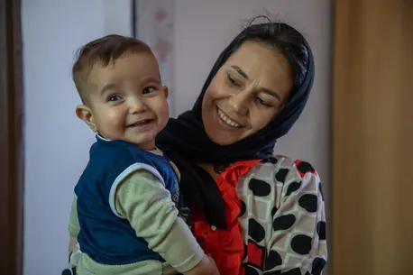 Mother and one year old child smiling
