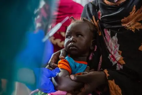 Small child being held by her mother.