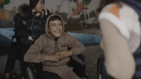 In North Gaza, a smiling boy sits in his new wheelchair, delivered by UNICEF.