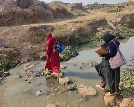 A vaccinator carrying a vaccine cold box travels by foot to reach communities where children are waiting to be immunized against polio as part of a national campaign..