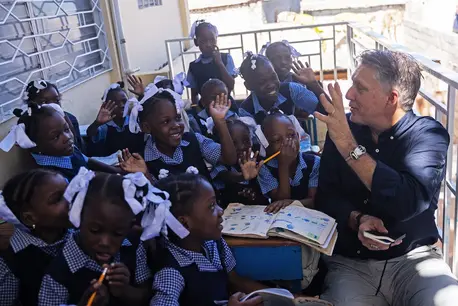 In Port-au-Prince on Jan. 27, 2025, UNICEF Global Spokesperson James Elder interacts with students during a visit to a school that UNICEF and partners relocated from La Saline in 2023, after students got caught up in a clash between two armed groups.