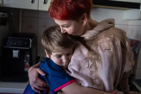 Ten-year-old Andrii embraces his mother in their kitchen in Kherson, eastern Ukraine. The boy has known nothing but war.