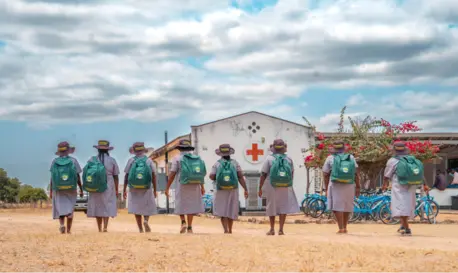 Female Village Health Workers with backpacks and backs turned to camera in Zimbabwe