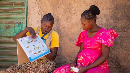 Community based health worker Adeline Ouédraogo explains to Odile Konkobo, 25, what the interest of MMS is in Ziniaré, Burkina Faso.