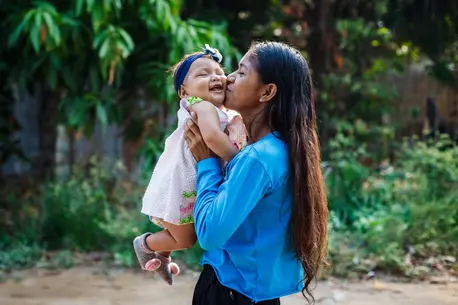 A mother holds her smiling infant daughter close after a visit with a UNICEF-supported mobile health brigade providing child vaccinations in Vichada, Colombia..