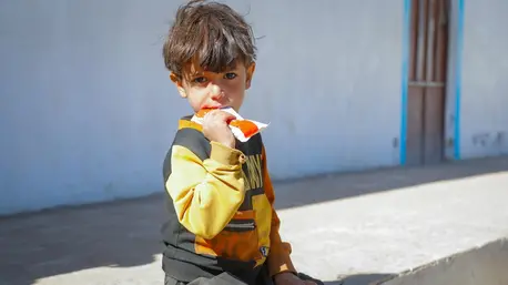 A malnourished child eats Ready-to-Use Therapeutic Food after being screened and diagnosed at the UNICEF-supported mobile clinic in Dhamar, Yemen.