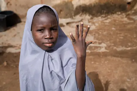 A 12-year-old girl in Katsina, Nigeria, shows her nail marked with ink indicating that she has been vaccinated against the human papillomavirus (HPV).