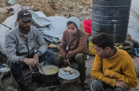A Palestinian family prepares dinner in a makeshift tent camp on Gaza City's Omar Al Mokhtar Street.