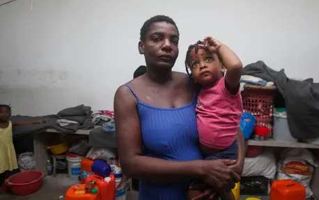 A mother holds her child inside a shelter for displaced families in Port-au-Prince, Haiti.