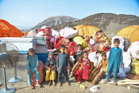 Children with family belongings at the Omari Camp reception center at Afghanistan's eastern Torkham border with Pakistan.