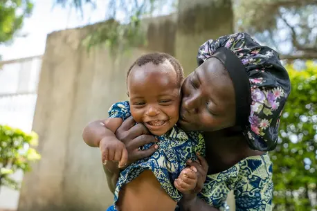 After feeding, a mother plays with her baby at a UNICEF nutrition event in Uganda on April 23, 2025.