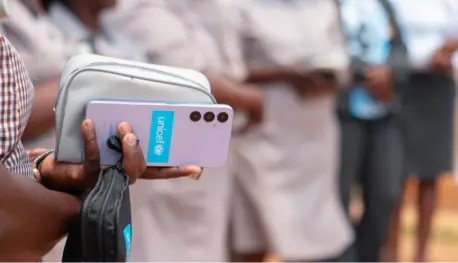 Woman's hand holds smartphone with UNICEF logo on the back of the device