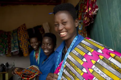 UNICEF-supported adolescent girls in Burundi show clothing they made in their shop.