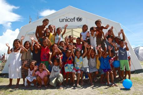 children play outside a tent serving as a UNICEF child-friendly space in the town of Tanauan – one of the areas hardest hit by the disaster – in Leyte Province, Eastern Visayas Region
