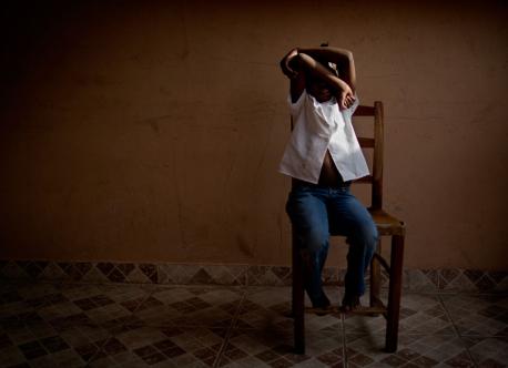 [NAMES CHANGED] Eight-year-old Marie hides her face in a dormitory in the Dominican Republic.