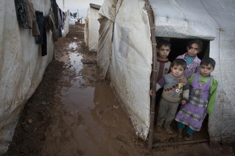 On 1 January, children stand in the entryway of their tent shelter, in the Bab Al Salame camp for internally displaced persons, near the border with Turkey, in Aleppo Governorate. © UNICEF/NYHQ2014-0003/Diffidenti; 