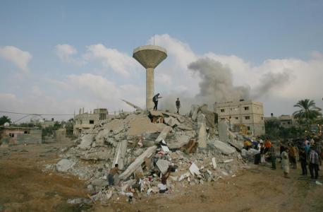 People search for victims amid the rubble of a destroyed home in the town of Rafah, southern Gaza. A cloud of smoke is visible in the distance. © UNICEF/NYHQ2014-1045/El Baba