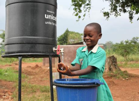 A young girl washes her hands with soap after using the latrine in Uganda.