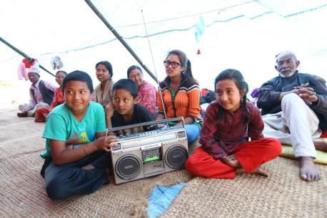 Nepal Earthquakes 2015: Children listen to a segment of the UNICEF-supported "Bhandai-Sundai" radio program at an informal camp for people displaced by the April 25 earthquake.